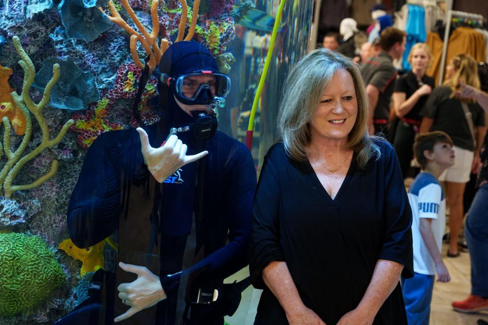 Darla Holt takes a photo with the scuba diver at Scheels at the Chandler Fashion Center on Sept. 30, 2023, in Chandler.