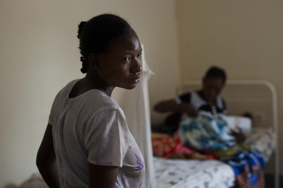 Alice Kabuya Kabeya, 20, stands in the Masaidizi Health Center in Lubumbashi, Democratic Republic of the Congo on Tuesday, Aug. 14, 2018. She gave birth to her daughter at the facility and cannot pay the $150 medical bill. Her jobless husband is trying to gather the funds so she had their daughter can be released. (AP Photo/Jerome Delay)