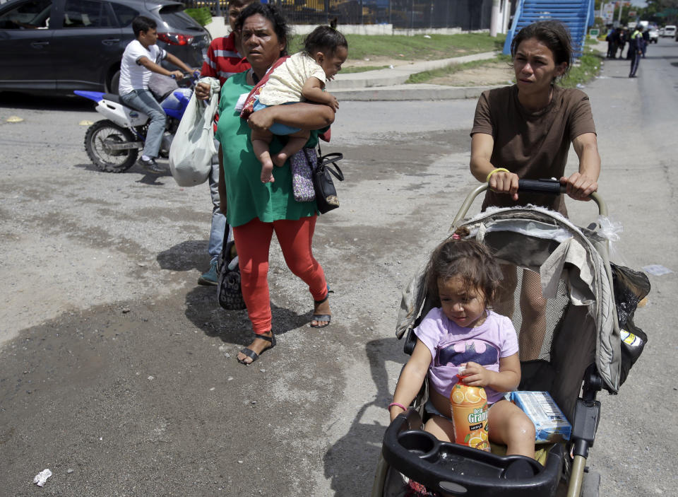 A couple of Hondruasn migrant mothers carry their children as they continue on their trek to the United States, in Teculutan, Guatemala, Wednesday, Oct. 17, 2018. The group of some 2,000 Honduran migrants hit the road in Guatemala again Wednesday, hoping to reach the United States despite President Donald Trump's threat to cut off aid to Central American countries that don't stop them. (AP Photo/Moises Castillo)