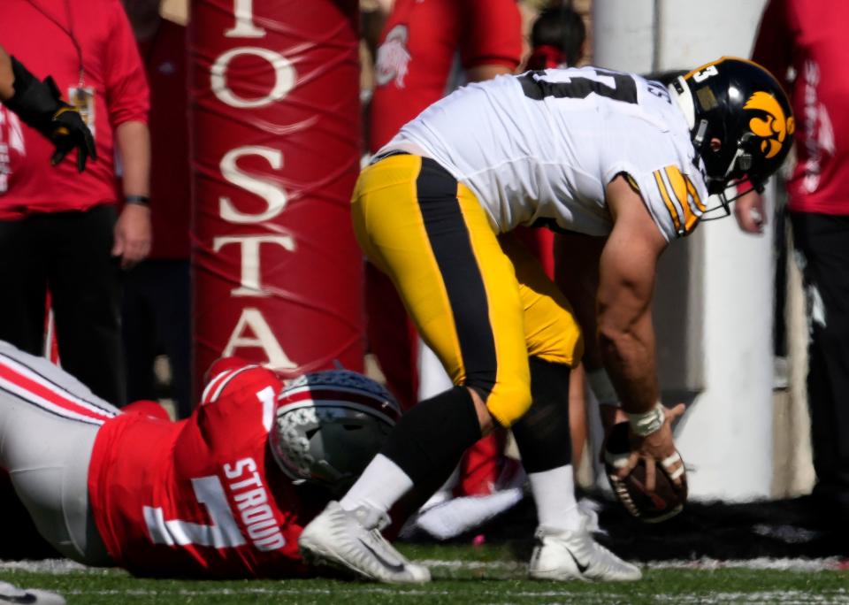 Iowa defensive end Joe Evans picks up a fumble by Ohio State quarterback C.J. Stroud and runs for a touchdown on Saturday.