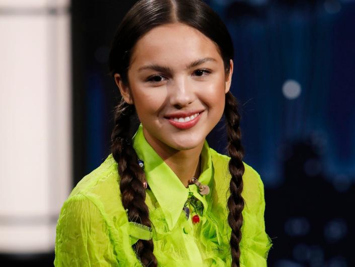 Olivia Rodrigo wearing a bright green blouse and her hair in two braids during an appearance on &quot;Jimmy Kimmel Live&quot; in October 2021.