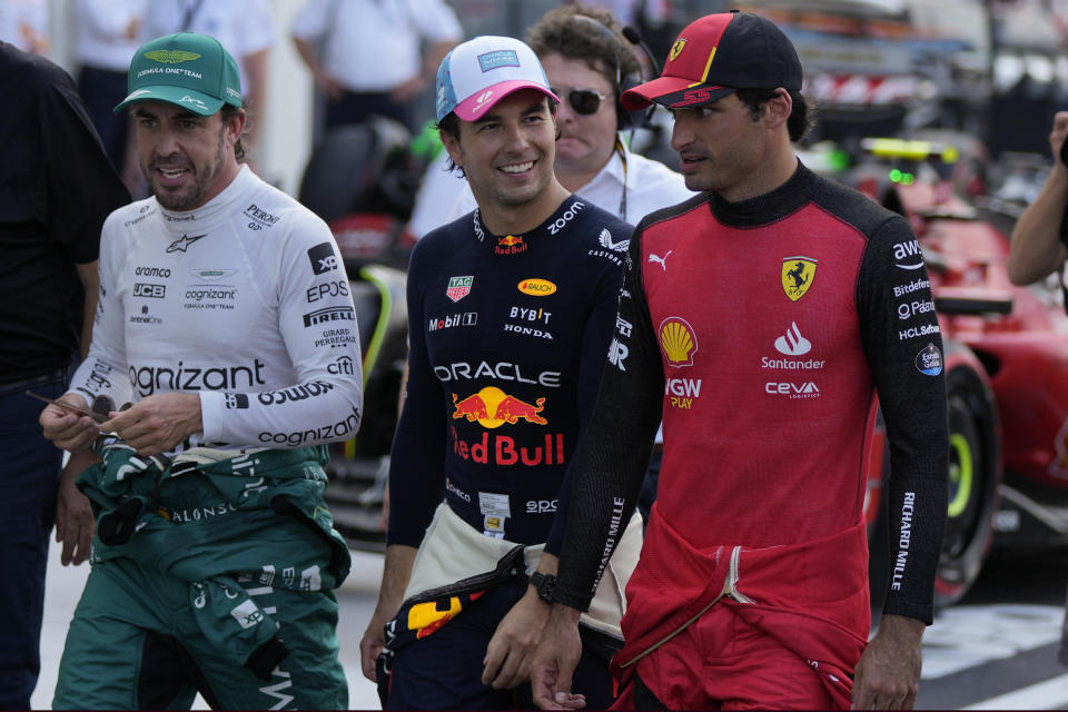 First place finisher, Red Bull driver Sergio Perez of Mexico, center, walks with second place finisher Aston Martin driver Fernando Alonso of Spain, left, and third place finisher Ferrari driver Carlos Sainz of Spain, at the end of the qualifying session of the Formula One Miami Grand Prix auto race, at Miami International Autodrome in Miami Gardens, Fla., Saturday, May 6, 2023. (AP Photo/Rebecca Blackwell)