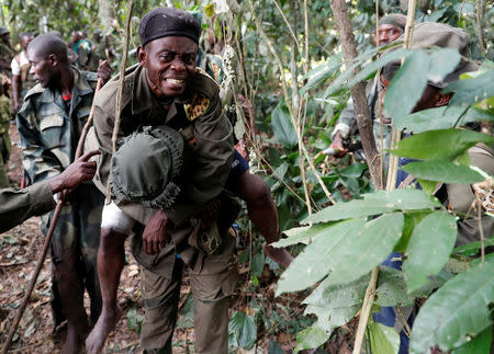 A wounded Congolese soldier from the Armed Forces of the Democratic Republic of Congo (FARDC) is carried by another soldier in the forest after the army took control of an ADF rebel camp, near the town of Kimbau, North Kivu Province, Democratic Republic of Congo, February 19, 2018. REUTERS/Goran Tomasevic/Files