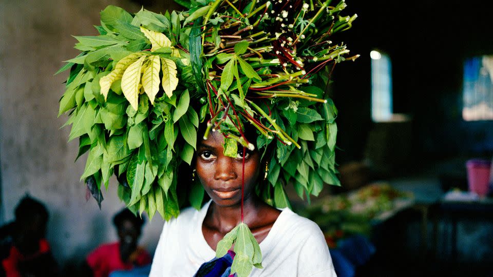 A woman brings cassava leaves into the central market area of Tubmanberg, Liberia in May 2003. - Tim Hetherington