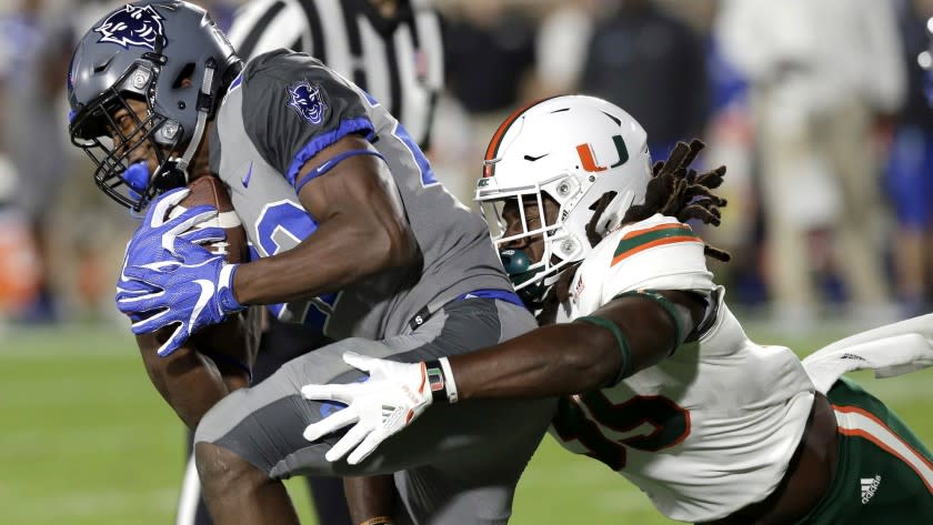 Miami's Mike Smith, right, reaches to tackle Duke's Brittain Brown during the first half of an NCAA college football game in Durham, N.C., Friday, Sept. 29, 2017. (AP Photo/Gerry Broome)