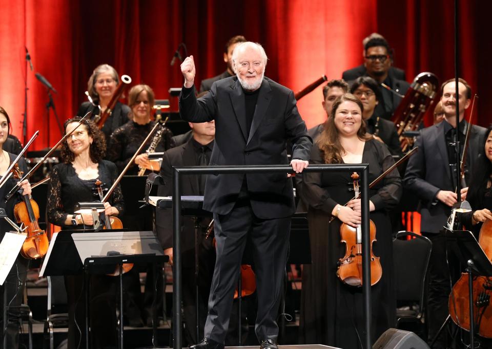 John Williams acknowledging the crowd with the orchestra behind him