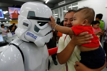 A member of a Star Wars fan club in Thailand, dressed as a Stormtrooper plays with a child during Star Wars Day celebration at the Queen Sirikit National Institute of Child Health in Bangkok, Thailand, May 4, 2016. REUTERS/Chaiwat Subprasom