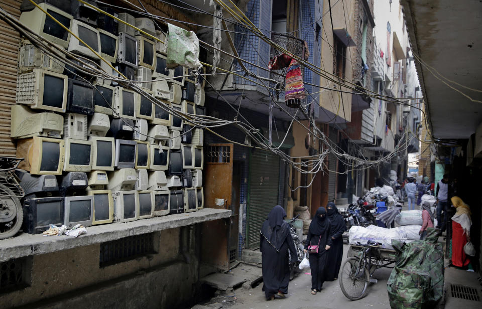 In this Saturday, Dec. 8, 2018 photo discarded television sets are stacked up in an alleyway in an area known for storing electronic waste in New Delhi, India. As politicians haggle at a U.N. climate conference in Poland over ways to limit global warming, the industries and machines powering our modern world keep spewing their pollution into the air and water. (AP Photo/Altaf Qadri)