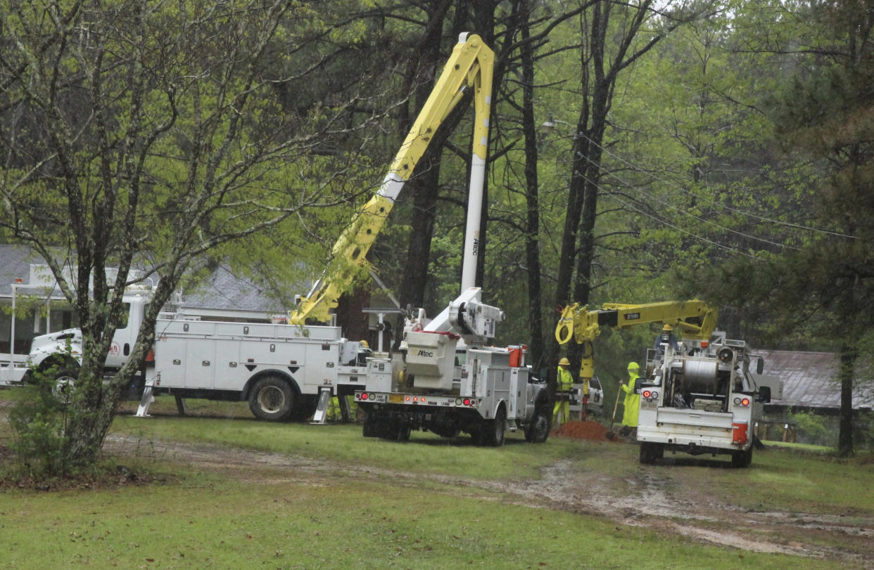 A crew with East Mississippi Power Electric Association works to restore power to a home in the Whynot Community in Lauderdale County, Miss. following a storm on Tuesday, April 5, 2022. (Bill Graham/The Meridian Star via AP)