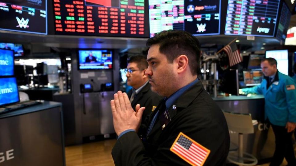 Un hombre con las manos rezando en la bolsa de Nueva York.