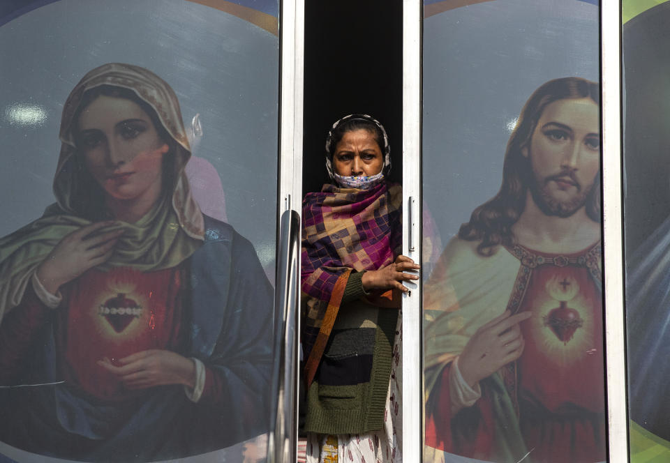 A Christian woman partially wearing a face mask as a precaution against the coronavirus leaves after attending a Christmas mass at a church in Gauhati, India, Friday, Dec. 25, 2020. (AP Photo/Anupam Nath)