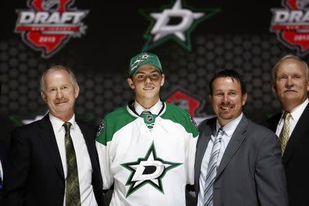 FILE PHOTO: Jason Dickinson poses with team executives in a Dallas Stars jersey after being selected by the Stars as the 29th overall pick in the 2013 National Hockey league (NHL) draft in Newark, New Jersey, June 30, 2013. REUTERS/Brendan McDermid