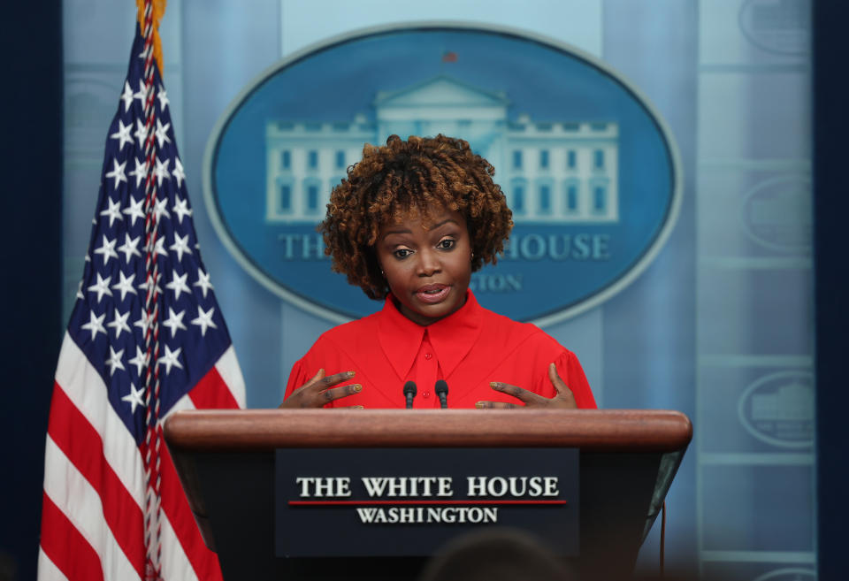 Karine Jean-Pierre at the podium in the White House press briefing room.