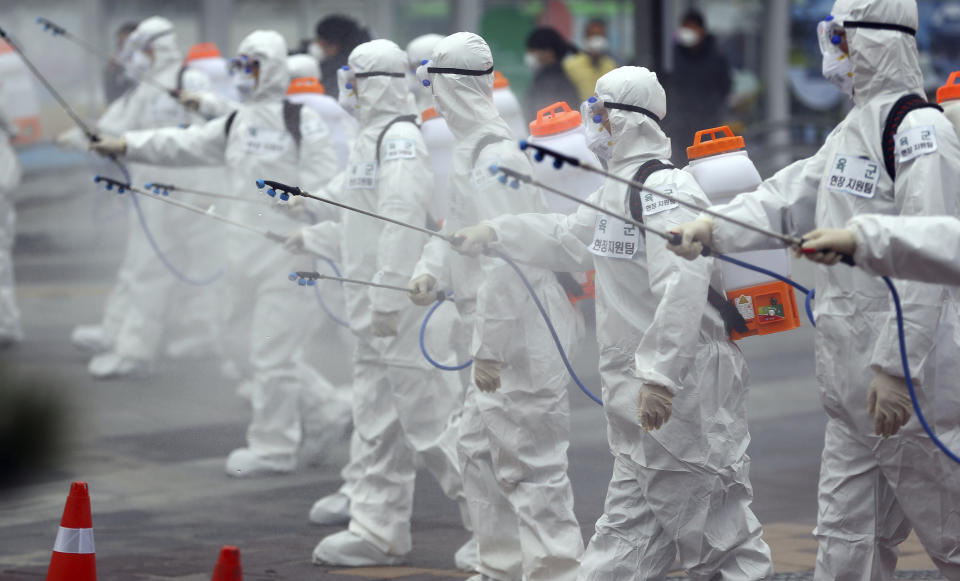 Soldados del ejército vestidos con trajes de protección rocían desinfectante para evitar la propagación de un nuevo coronavirus en la estación de tren de Dongdaegu, en Daegu, Corea del Sur, el 29 de febrero de 2020. (Kim Hyun-tai/Yonhap vía AP)