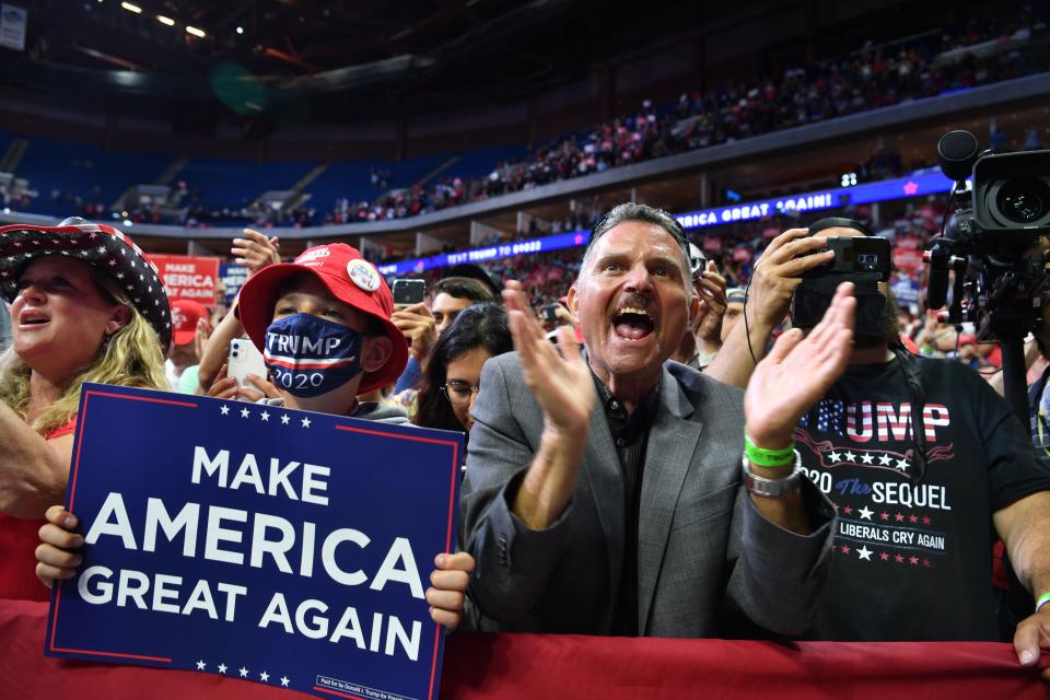 Supporters cheer as they listen to US President Donald Trump speaks during a campaign rally at the BOK Center on June 20, 2020 in Tulsa, Oklahoma. - Hundreds of supporters lined up early for Donald Trump's first political rally in months, saying the risk of contracting COVID-19 in a big, packed arena would not keep them from hearing the president's campaign message. (Photo by Nicholas Kamm / AFP) (Photo by NICHOLAS KAMM/AFP via Getty Images)