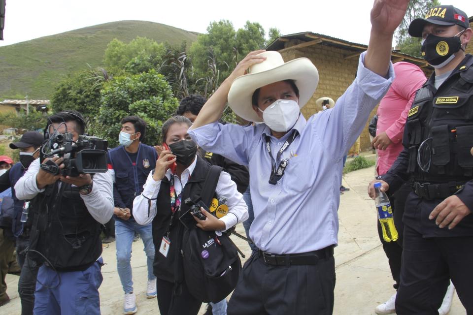 In this photo released by Peruvian news agency Andina, Peru Libre party presidential candidate Pedro Castillo waves at supporters after casting his ballot in the general elections in Cajamarca, Peru, Sunday, April 11, 2021. (POOL via AP)