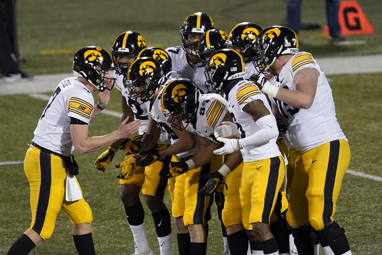 Iowa quarterback Spencer Petras calls a play in the huddle during the second half of an NCAA college football game against Illinois Saturday, Dec. 5, 2020, in Champaign , Ill. Iowa won 35-21. (AP Photo/Charles Rex Arbogast)