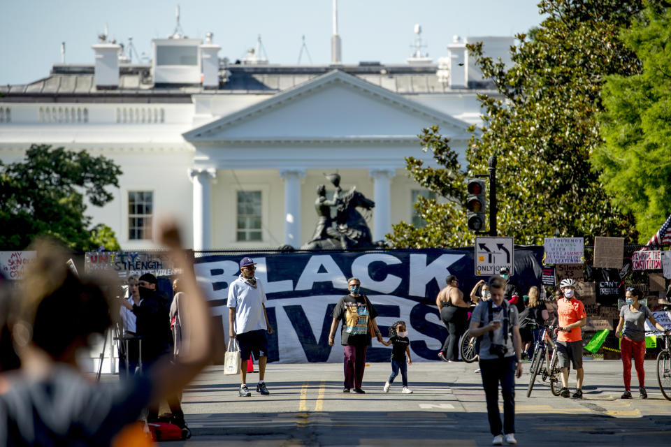 People make their way along 16th Street, Monday, June 8, 2020, near the White House in Washington, after days of protests over the death of George Floyd, a black man who was in police custody in Minneapolis. Floyd died after being restrained by Minneapolis police officers. (AP Photo/Andrew Harnik)