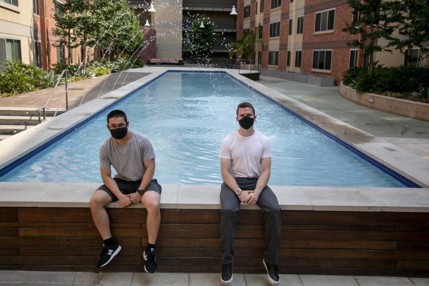 LOS ANGELES, CA - AUGUST 20: USC students Ethan Recinto, 21, of Illinois and Robert Beyer, 21, of New Jersey pose outside University Gateway Apartments on Thursday, Aug. 20, 2020 in Los Angeles, CA. University Gateway has a reputation as a party location and that hasn't changed despite coronavirus.(Josie Norris / Los Angeles Times)