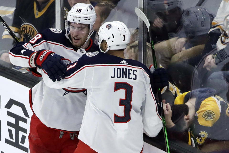 Columbus Blue Jackets center Pierre-Luc Dubois (18) celebrates his winning goal against the Boston Bruins with teammate Seth Jones (3) in the overtime period of an NHL hockey game, Thursday, Jan. 2, 2020, in Boston. (AP Photo/Elise Amendola)