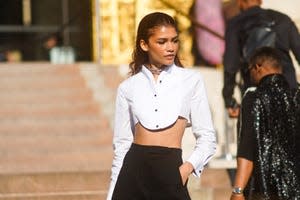 Zendaya wears a white crop shirt, black pants, outside Armani, during Paris Fashion Week -Haute Couture Fall/Winter 2019/2020, on July 02, 2019 in Paris, France.