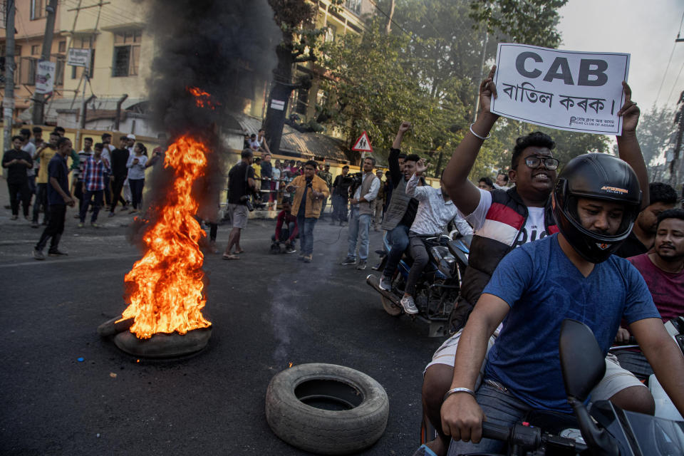 Indian protesters burn tires on a road during a shutdown protest against the Citizenship Amendment Bill (CAB) in Gauhati, India, Tuesday, Dec. 10, 2019. Opponents of legislation that would grant Indian citizenship to non-Muslim illegal migrants from Pakistan, Bangladesh and Afghanistan have enforced an 11-hour shutdown across India's northeastern region. (AP Photo/Anupam Nath)