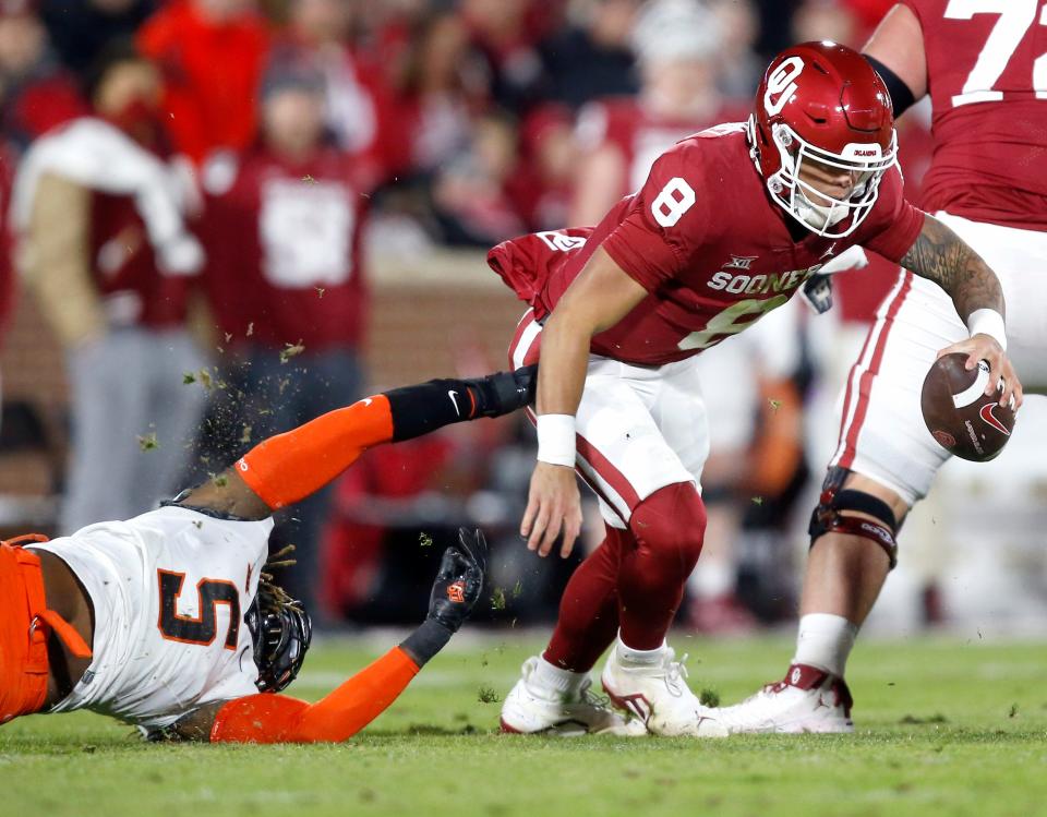 Oklahoma's Dillon Gabriel (8) gets by Oklahoma State's Kendal Daniels (5) in the first half during the Bedlam college football game between the University of Oklahoma Sooners (OU) and the Oklahoma State University Cowboys (OSU) at Gaylord Family-Oklahoma Memorial Stadium, in Norman, Okla., Saturday, Nov., 19, 2022. 