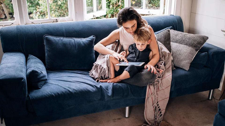 a mother and son look at a tablet