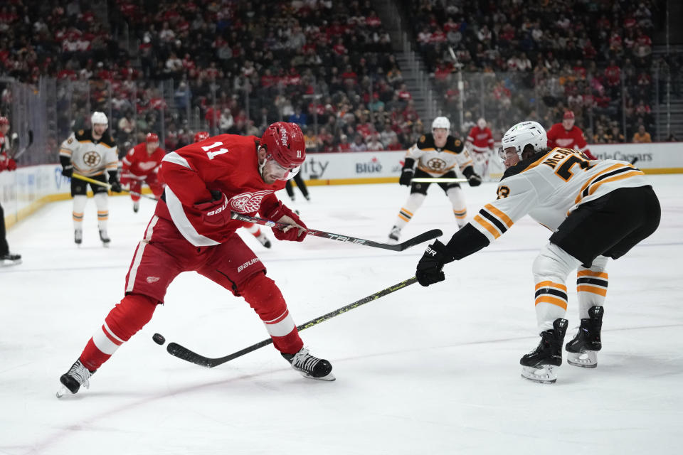Boston Bruins defenseman Charlie McAvoy (73) knocks the puck from Detroit Red Wings right wing Filip Zadina (11) in the first period of an NHL hockey game Sunday, March 12, 2023, in Detroit. (AP Photo/Paul Sancya)