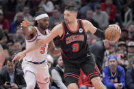 Chicago Bulls Nikola Vucevic (9) pushes around New York Knicks Precious Achiuwa (5) during the second quarter of an NBA basketball game in Chicago, Friday, April 5, 2024. (AP Photo/Mark Black)