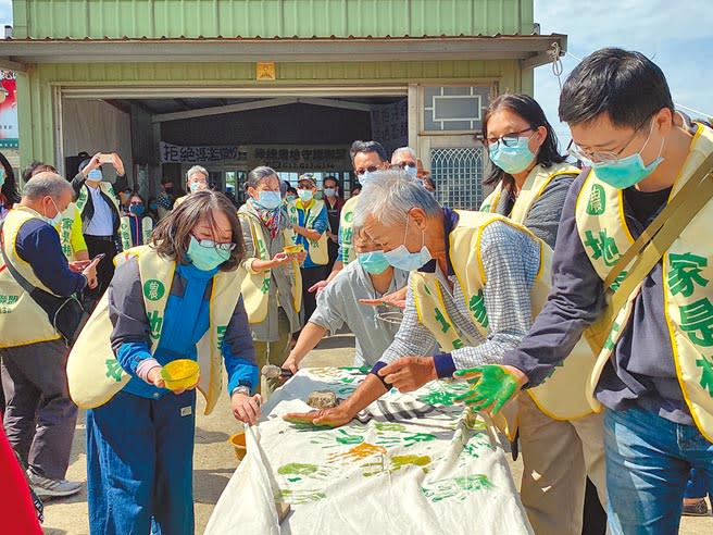 綠捷農地守護聯盟百位地主，24日高喊「家是根、地是本」，一一押下掌印，象徵一同「手」護農地。（蔡依珍攝）