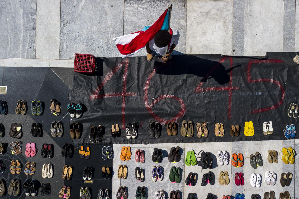 In this aerial photo, a demonstrator holds a Puerto Rican flag near empty pairs of shoes at the Puerto Rican Capitol during the protest June 1. (Photo: Xavier Garcia/Bloomberg)