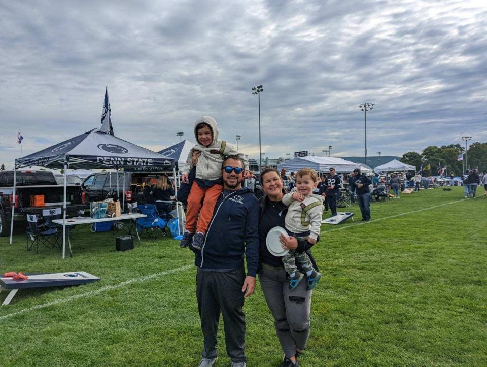 Michael Babcock (left) holding son Colton, with wife, Karen, holding son Dax at a Penn State tailgate.  Dax was killed by a falling tree branch on April 22, 2023.