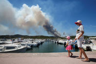 <p>A woman and her daughter walk near leisure boats in a port as a plume of smoke from burning fires fills the sky in Bormes-les-Mimosas, in the Var department, France, July 26, 2017. (Jean-Paul Pelissier/Reuters) </p>