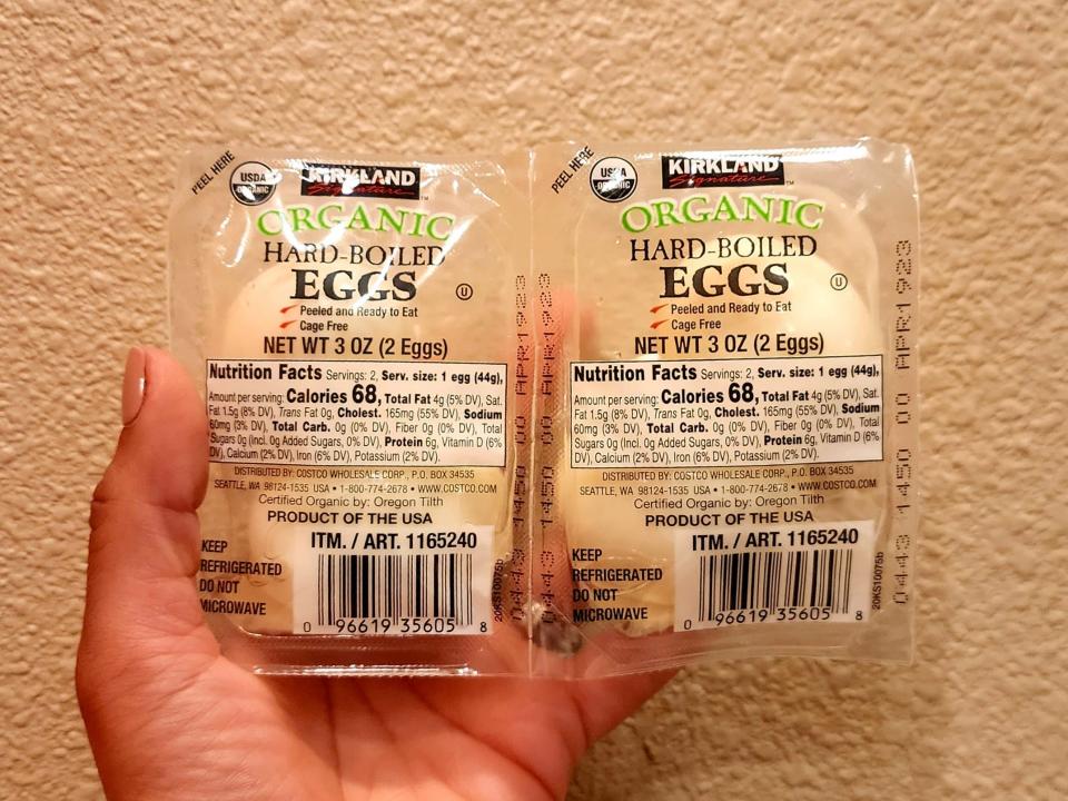The writer holds a two-pack of Kirkland Signature hard-boiled eggs