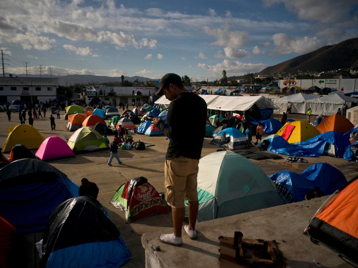 A migrant does a crossword puzzle at the new shelter where he and others were transferred after the sanitary conditions worsened at a previous shelter in Tijuana: AP