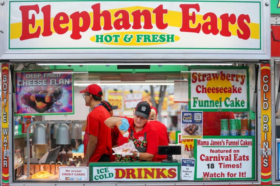 Mama Jane Harris añade cobertura de dulce de leche a bocados de flan de queso frito durante el día de apertura de la Feria de la Juventud del Condado Miami-Dade en el Miami-Dade Fair & Expo Center, en Miami, Florida, el jueves 17 de marzo de 2022.