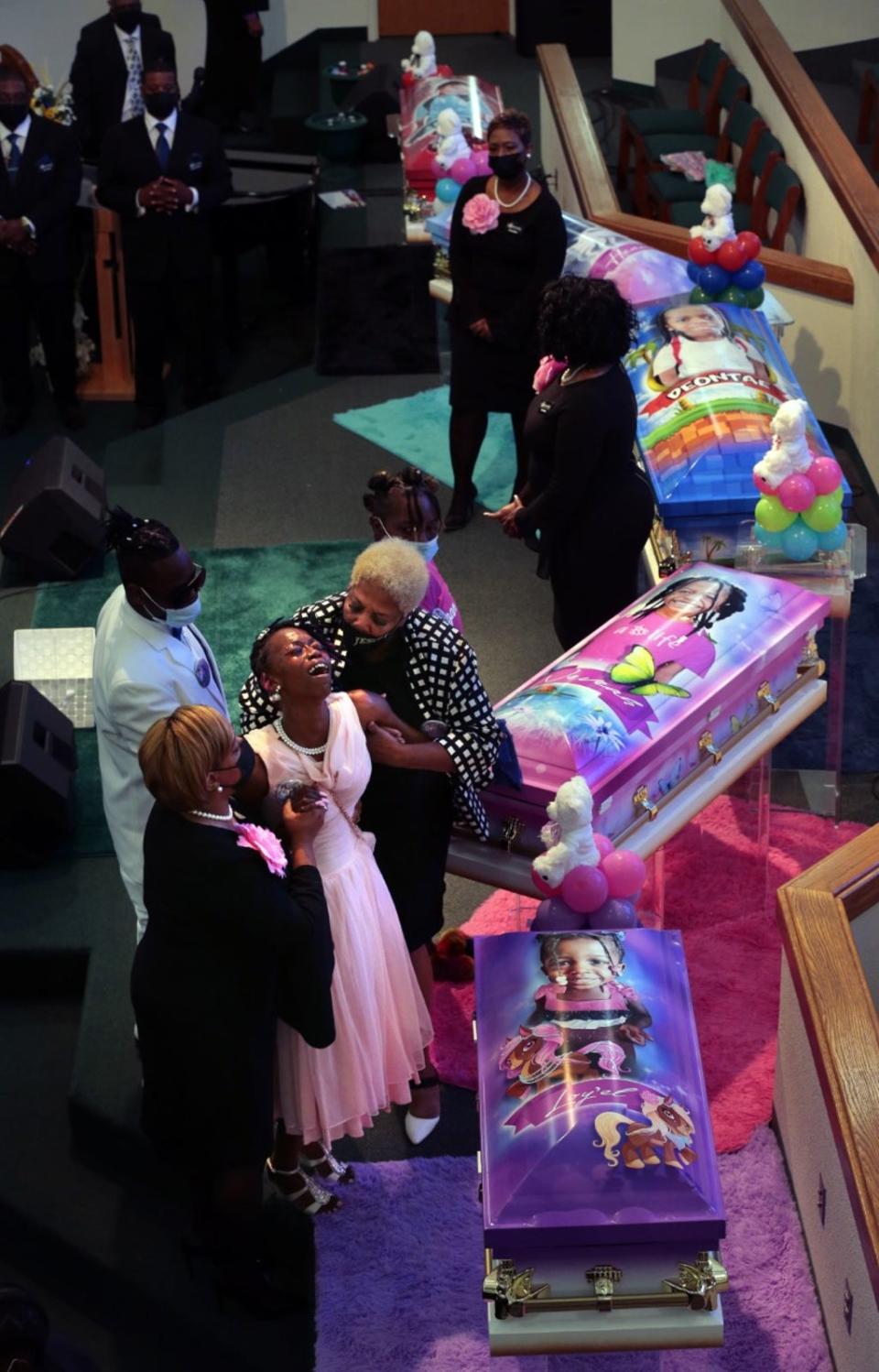 Sabrina Dunigan had to be helped through the August 21 funeral for her five children. She now faces charges in connection with the fire deaths of Heaven and Neveah Dunigan, 8;   Deontae Davis Jr, 9; Jabari Johnson, 4; and Loy-el Dunigan, 2 (Associated Press)