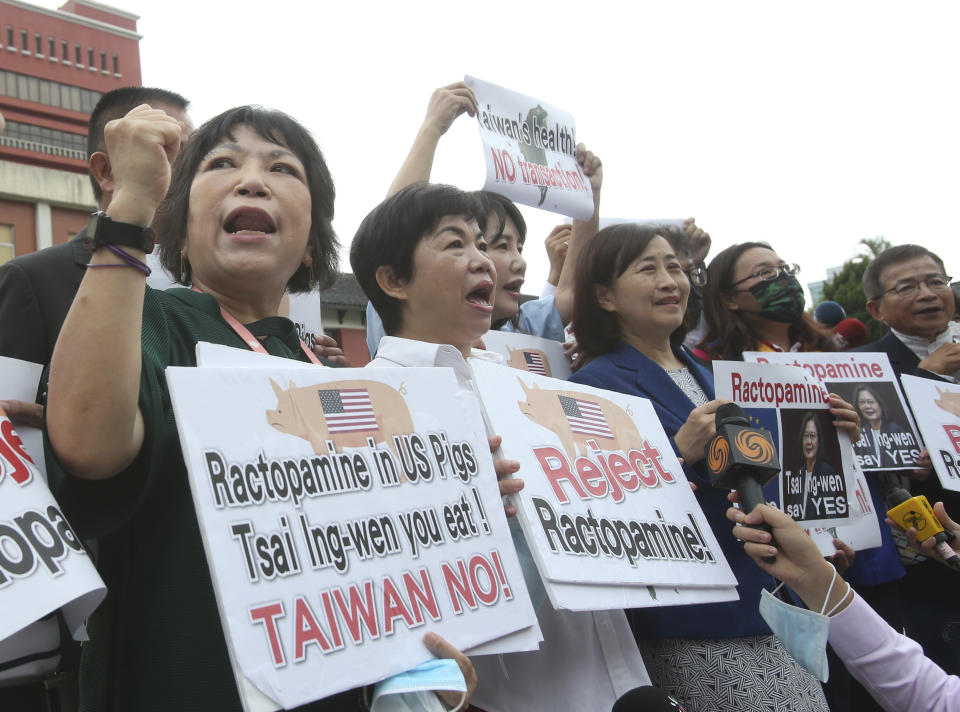 National party legislators hold slogans to protest against the relaxation of statutory restrictions from U.S beef and pork at the Legislative Yuan in Taipei, Taiwan, Tuesday, Sept. 1. 2020. (AP Photo/Chiang Ying-ying)