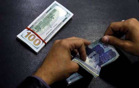 A currency trader counts Pakistani rupee notes as he prepares an exchange of U.S. dollars in Islamabad, Pakistan December 11, 2017. REUTERS/Caren Firouz/Files