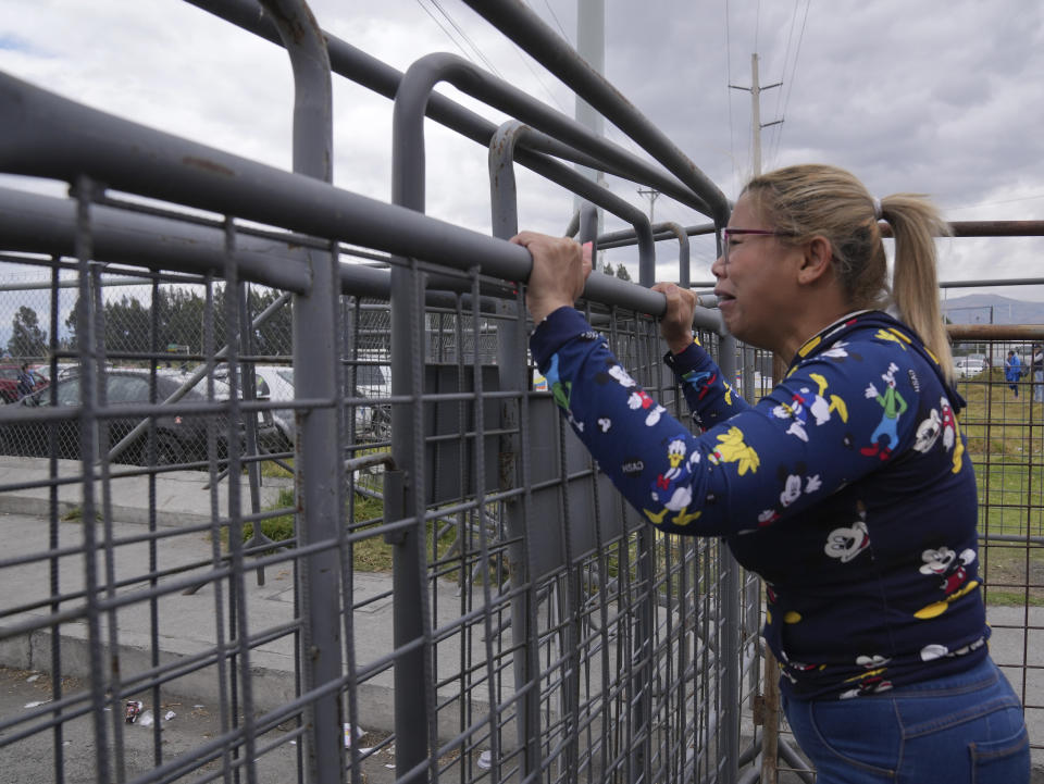 A woman cries as she waits for news of her loved one after a deadly prison riot in Latacunga, Ecuador, Tuesday, Oct. 4, 2022. A clash between inmates armed with guns and knives inside the prison has left at least 15 people dead and 20 injured. (AP Photo/Dolores Ochoa)