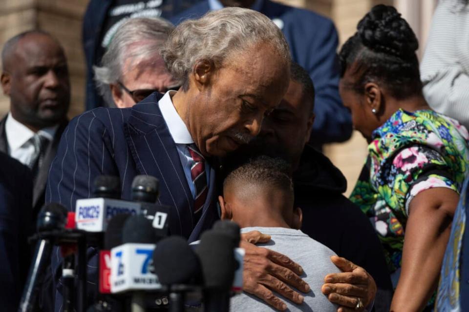 The Rev. Al Sharpton hugs Jaques “Jake” Patterson, the 12-year-old son of Buffalo shooting victim, Heyward Patterson, on May 19, 2022 during a press conference outside the Antioch Baptist Church in Buffalo, N.Y. (AP Photo/Joshua Bessex)