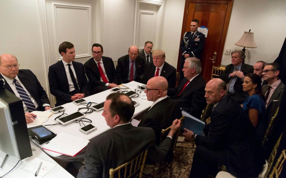 President Donald Trump receives a briefing on the Syria military strike from his National Security team, including a video teleconference with Secretary of Defense, Gen. James Mattis, and Chairman of the Joint Chiefs of Staff, Gen. Joseph Dunford, on Thursday, April 6, 2017, in a secured location at Mar-a-Lago in Palm Beach, Fla - Credit: AP