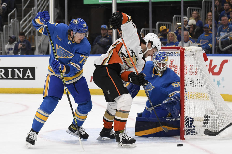 St. Louis Blues goaltender Jordan Binnington (50) and Tyler Tucker (75) defend the net from Anaheim Ducks' Mason McTavish (37) during the first period of an NHL hockey game, Saturday, Nov. 19, 2022, in St. Louis. (AP Photo/Jeff Le)