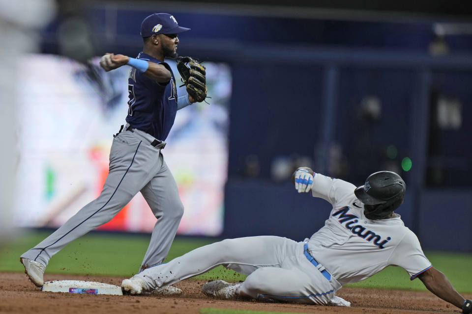 Tampa Bay Rays shortstop Vidal Brujan puts out Miami Marlins' Jorge Soler at second base and attempts to put out the runner at first during the first inning of a baseball game, Tuesday, Aug. 29, 2023, in Miami. (AP Photo/Wilfredo Lee)