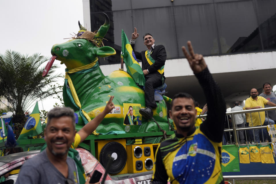 An impersonator of Brazilian President Jair Bolsonaro rides a cow statue during Bolsonaro's campaign event for reelection in Duque de Caxias, Rio de Janeiro state, Brazil, Friday, Oct. 14, 2022. The presidential run-off election is set for Oct. 30. (AP Photo/Silvia Izquierdo)