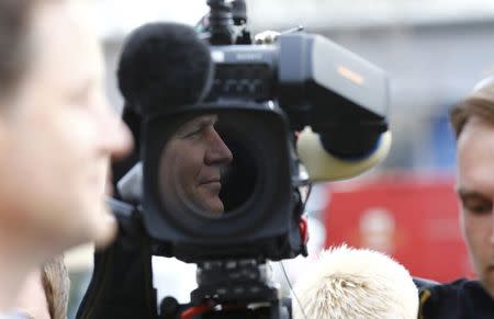 Britain's Liberal Democrat party leader and Deputy Prime Minister Nick Clegg is reflected in a television camera lens as he speaks with members of the media after a visit to Millie's Trust in Manchester, northern England, April 2, 2015. REUTERS/Darren Staples