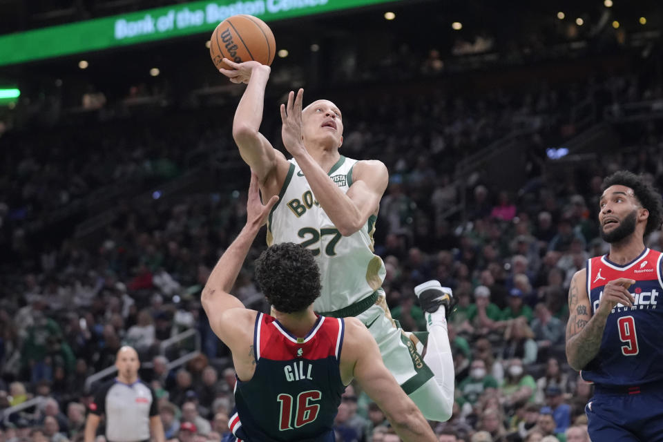 Boston Celtics guard Jordan Walsh (27) takes a shot at the basket over Washington Wizards forward Anthony Gill (16) as forward Justin Champagnie (9) defends in the first half of an NBA basketball game, Sunday, April 14, 2024, in Boston. (AP Photo/Steven Senne)