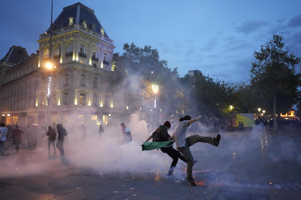 Protestors kick in a tear gas canister during a rally in solidarity with the Palestinian people in Gaza, in Paris, Thursday, Oct.12, 2023. (AP Photo/Thibault Camus)