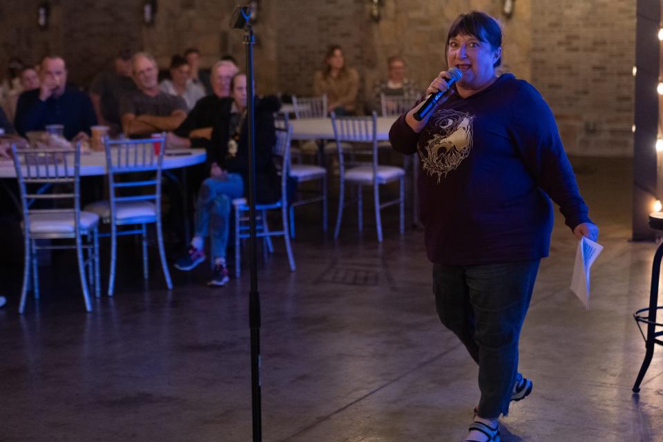 Vicki Trembly, co-owner of Top City Comedy, is comfortable in front of a microphone as she introduces the next comic during a competition Thursday night.